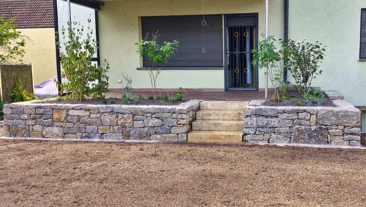 Natursteinmauer und Terrasse im Garten